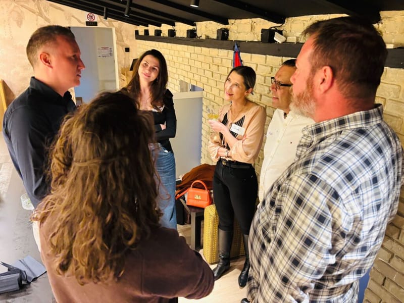 Group of five attendees in conversation at a 3rd Space Bucharest event in a room with exposed stone walls