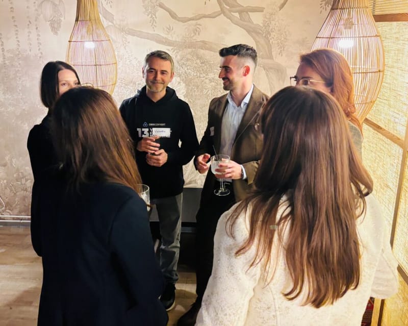 Four guests in a circle conversation at a 3rd Space Bucharest event, bamboo pendant lights and a nature mural behind them